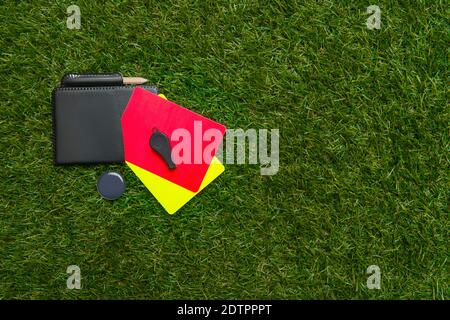 Football soccer referee equipment on green grass background. Top view, space for your text. Stock Photo