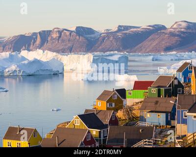 View of fjord full of icebergs towards Nuussuaq (Nugssuaq) peninsula during midnight sun. The town Uummannaq in the north of West Greenland, located o Stock Photo