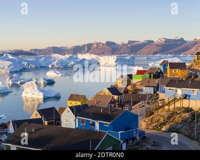 View of fjord full of icebergs towards Nuussuaq (Nugssuaq) peninsula during midnight sun. The town Uummannaq in the north of West Greenland, located o Stock Photo