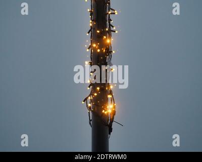 A closeup shot of Christmas lights wrapped on the post isolated on gray backgrou Stock Photo