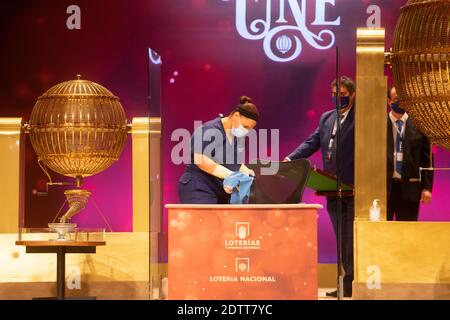 Madrid, Spain. 22 December, 2020: Cleaning staff clean where the official was sitting with the winning numbers during the the draw of Spain's Christmas lottery named 'El Gordo' (Fat One) on December 22, 2020 in Madrid, Spain.  Credit: Jon Imanol Reino/Alfa Images/Alamy Live News Stock Photo