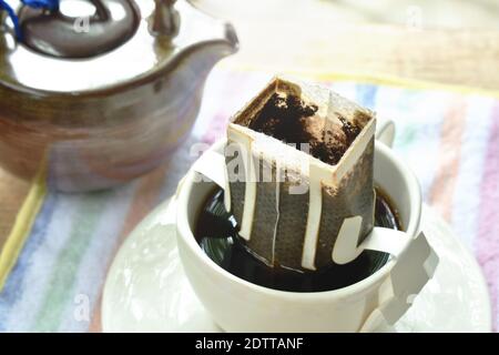coffee drip mixed by hot water pouring from ceramic jar on cup Stock Photo
