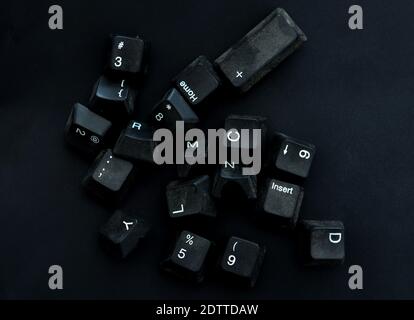 dirty and dusty black computer keyboard keys on a black background. Stock Photo