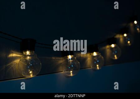 Decoration of lit light bulbs hanging in a dark room Stock Photo