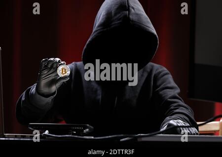 International hacker is trying to steel your crypto currency. Blockchain security. Thief with laptop is hacking governments computers. Phishing attacks. Stock Photo