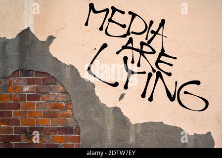 Handwritten graffiti Media Are Lying sprayed on the wall, anarchist aesthetics Stock Photo