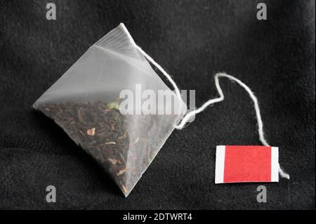 Clean new teabag with new tag on soft dark background Stock Photo