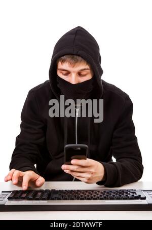 Hacker with a Mobile Phone and the Computer Keyboard on the White Background Stock Photo