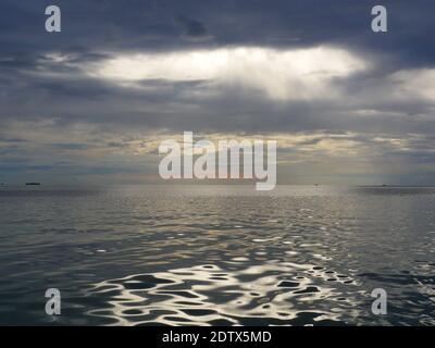 sea dramatic landscape with rays through a cloudy dark sky Stock Photo