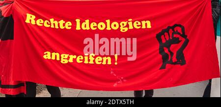 Red protest poster with a black fist and the yellow German inscription: Attacking right-wing ideologies Stock Photo