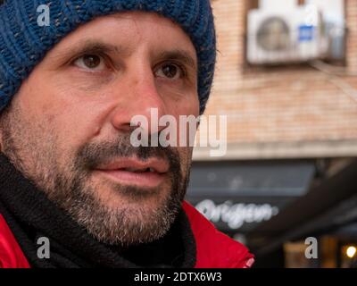 PORTRAIT OF MAN IN RED JACKET AND BLUE HAT Stock Photo