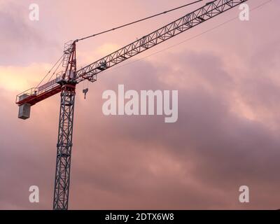 CONSTRUCTION CRANE WITH A BEAUTIFUL CLOUDY SKY AT SUNSET Stock Photo