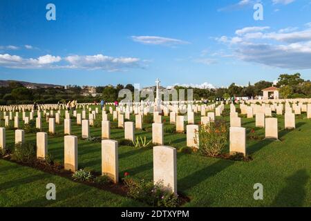 Rows of headstones and memorial cross in Souda Bay War Cemetery at sunrise, Chania region, Crete Island, Greece Stock Photo