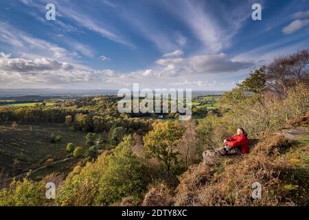Walker enjoying the view over the Cheshire Plain in autumn from Maiden Castle, Bickerton Hill, Cheshire, England, UK