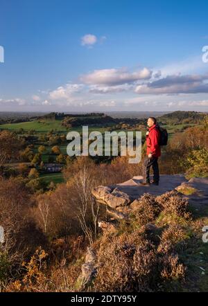 Walker enjoying the view over the Cheshire Plain from Kitty’s Stone viewpoint, Bickerton Hill, Cheshire, England, UK