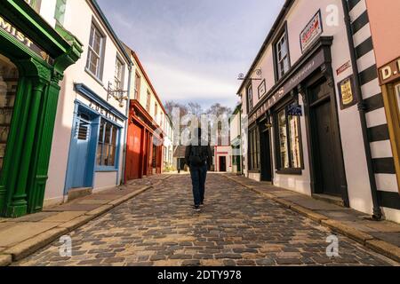 Omagh, County Tyrone, Northern Ireland 3-26-2017: The woman walking on empty streets of the old town of The Ulster American Folk Park Stock Photo