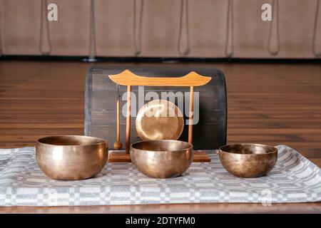 Tibetan handcrafted singing bowls on the floor in yoga class, sound therapy concept Stock Photo
