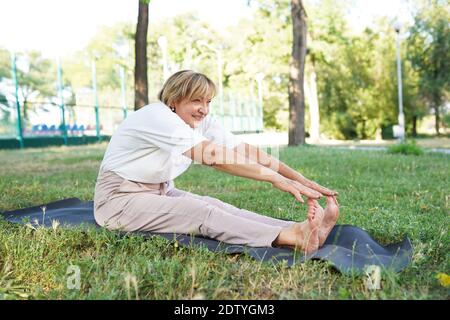 Graceful Woman Doing Yoga in City Park Smooth Physical Body Movement Stock Photo