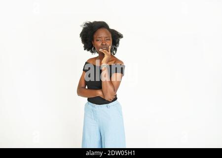 Serious dark-skinned female with black hair and charming dark eyes posing on camera at the studio on white background Stock Photo