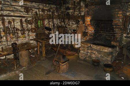 Antique vintage workshop with blacksmith's rusty tools and stone furnace Stock Photo