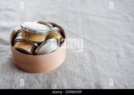 Nuts and seeds butter in glass jars on natural fabric background with copyspace. Homemade raw organic peanut, almond, coconut, hemp seeds, pumpkin Stock Photo