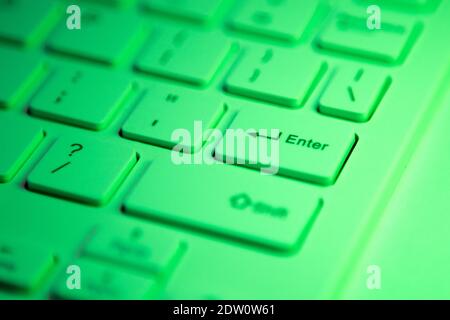 Close up detail of a Green highlighted enter key on a computer keyboard Stock Photo