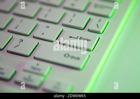 Close up detail of a Green highlighted enter key on a computer keyboard Stock Photo