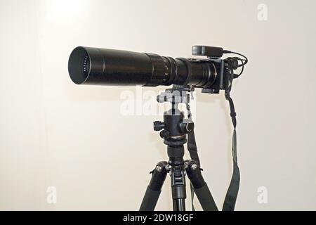 Camera with telephoto lens on tripod Stock Photo
