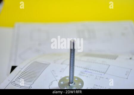 M8 bolt bonding fastener with blurred technical drawing and yellow background. Stock Photo