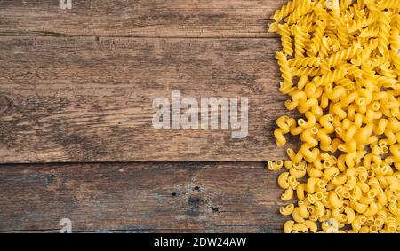 Assortment of different types of pasta on a wooden background. Stock Photo