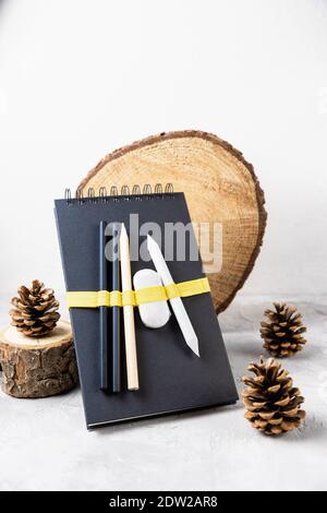 Sketchbook or notebook, pencil, eraser, pine cones Stock Photo