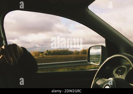 View through the moving car windscreen inside the car interior. Man drives a car. Stock Photo