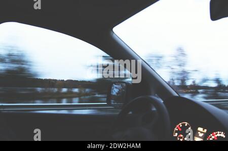 View through the moving car windscreen inside the car interior. Stock Photo