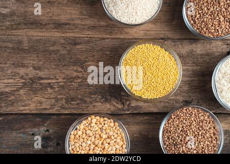 Bowls with different cereals on a wooden background. Stock Photo