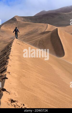Tourist walking a megadune ridge. Badain Jaran Desert-Inner Mongolia-China-1176 Stock Photo
