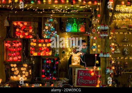 Barcelona, Spain. 22nd Dec, 2020. A vendor sitting among his illumination articles at a Christmas market wears a protective facemask due to the continuous spread of the coronavirus Credit: Matthias Oesterle/Alamy Live News Stock Photo