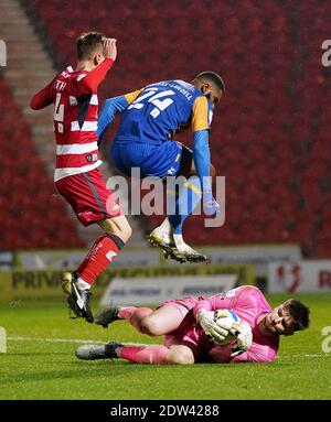 Doncaster Rovers' Matthew Smith (left) and Shrewsbury Town's Ethan Ebanks-Landell jump over Shrewsbury Town goalkeeper Matija Sarkic as he makes a save during the Sky Bet League One match at Keepmoat Stadium, Doncaster. Stock Photo