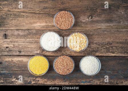 Different cereals on a wooden background. Top view, with space to copy. Stock Photo