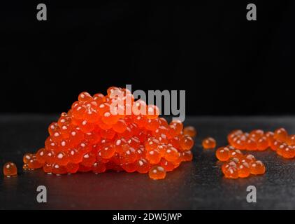 red grainy chum salmon caviar on black background, close up Stock Photo