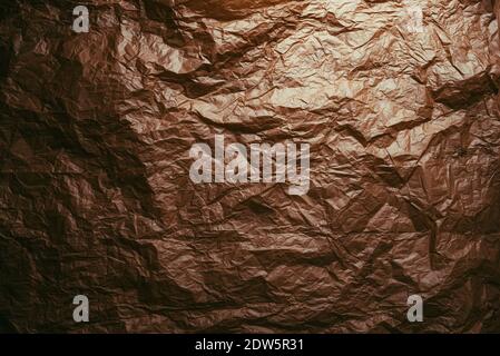 Crumpled and expanded paper with natural texture of reddish tones. Stock Photo