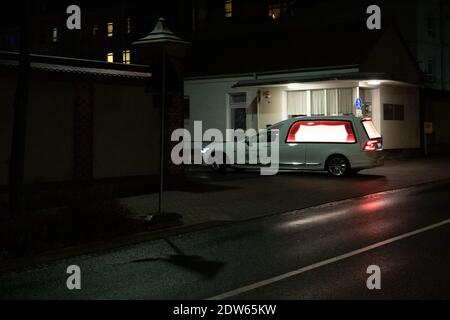 Zittau, Germany. 22nd Dec, 2020. A hearse drives into the driveway of the Klinikum Oberlausitz Bergland in the evening. Because of the dramatically high corona death rates in Zittau in eastern Saxony, corpses have to be temporarily stored there outside the crematorium. Credit: Daniel Schäfer/dpa-Zentralbild/dpa/Alamy Live News Stock Photo