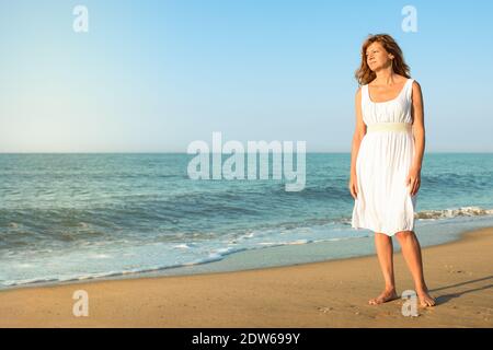 Mature woman enjoying herself on the beach Stock Photo - Alamy