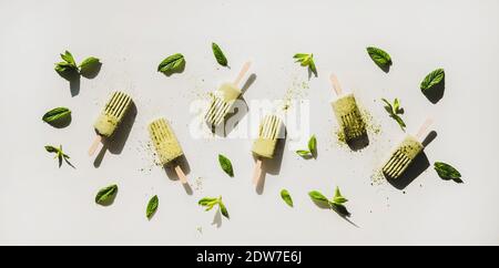 Green matcha coconut vegan ice cream popsicles with mint and matcha powder. Flat-lay of matcha popsicles over light background, top view. Summer healt Stock Photo