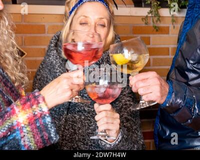 A happy shot of three friends having a good time and drinking delicious cocktails together - cheers Stock Photo
