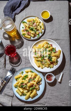 Italian recipe Pasta tortilloni with green pea, mint leaves smoked bacon and cheese. Stock Photo