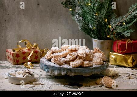 Homemade Christmas coconut gluten free cookies with coconut flakes on ceramic plate on old wooden table with xmas gifts and decorations. Stock Photo