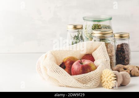 Red apples in reusable cotton bags and glass jars with pasta, lentils, beans, rice, dry herbs. Zero waste, Recycling, Sustainable lifestyle concept Stock Photo