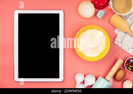 Baking background frame. Ingredients, kitchen items for baking and empty tablet. Kitchen utensils, flour, eggs, sugar. Text space, top view Stock Photo