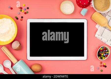 Baking background frame. Ingredients, kitchen items for baking and empty tablet. Kitchen utensils, flour, eggs, sugar. Text space, top view. Stock Photo
