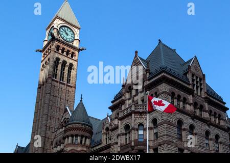 The waving Canadian flag with Old City Hall in background in Toronto, Canada. Stock Photo